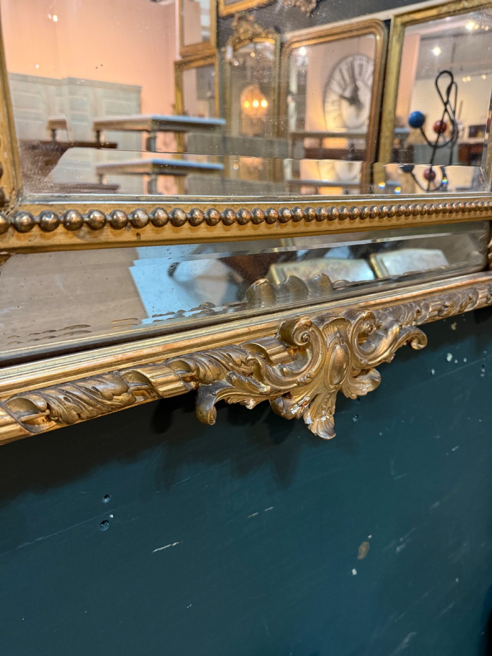 A 19th-century rectangular French giltwood wall mirror featuring elaborate cresting with cherubs, an urn finial, acanthus leaf scrolling, and a beaded inner border around a bevelled glass plate. View VI