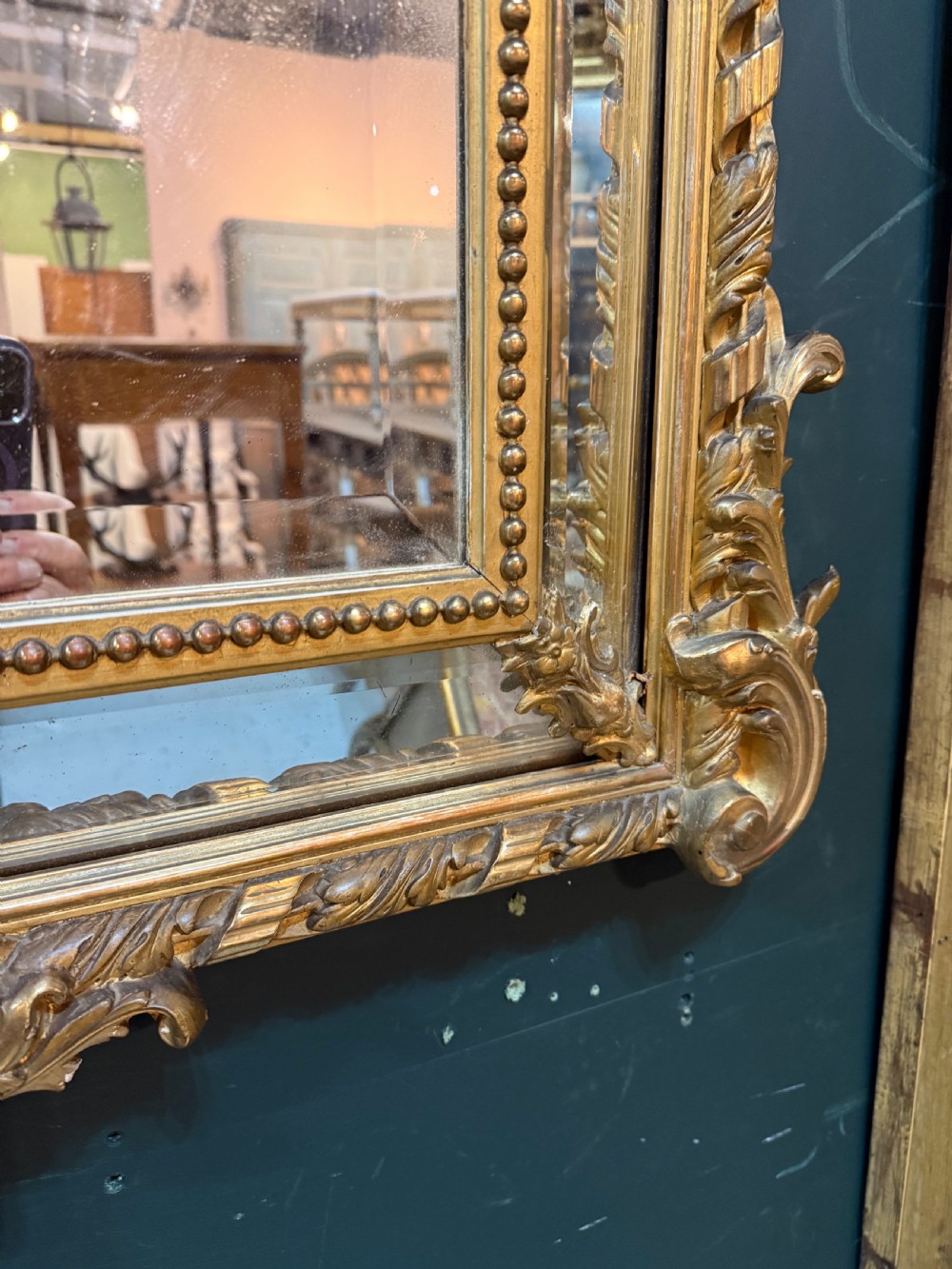 A 19th-century rectangular French giltwood wall mirror featuring elaborate cresting with cherubs, an urn finial, acanthus leaf scrolling, and a beaded inner border around a bevelled glass plate. View VII