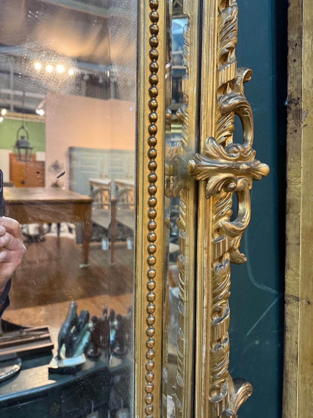 A 19th-century rectangular French giltwood wall mirror featuring elaborate cresting with cherubs, an urn finial, acanthus leaf scrolling, and a beaded inner border around a bevelled glass plate. View VIII
