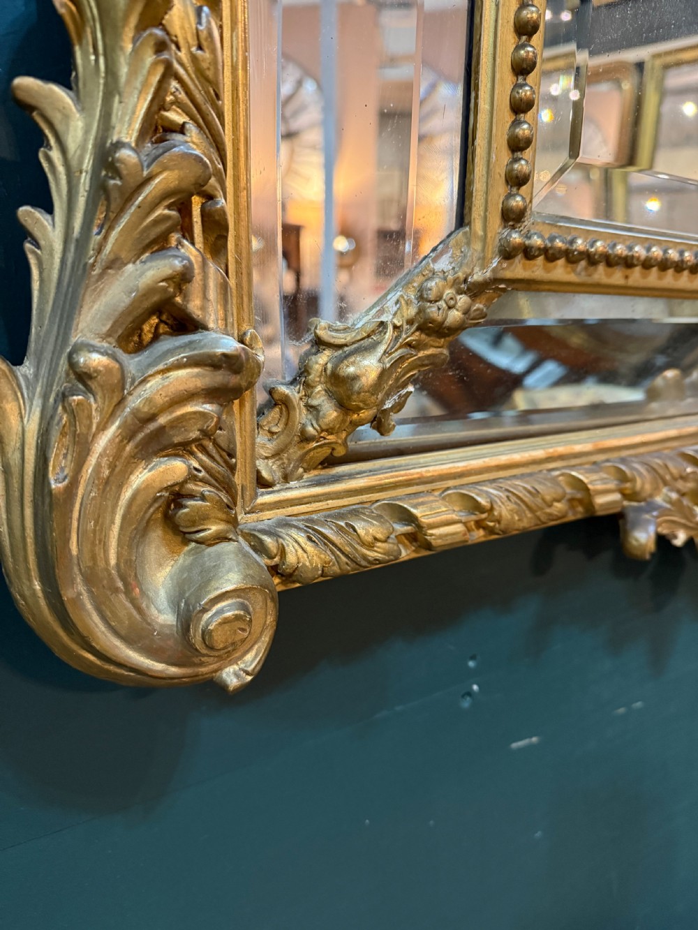 A 19th-century rectangular French giltwood wall mirror featuring elaborate cresting with cherubs, an urn finial, acanthus leaf scrolling, and a beaded inner border around a bevelled glass plate. View IX