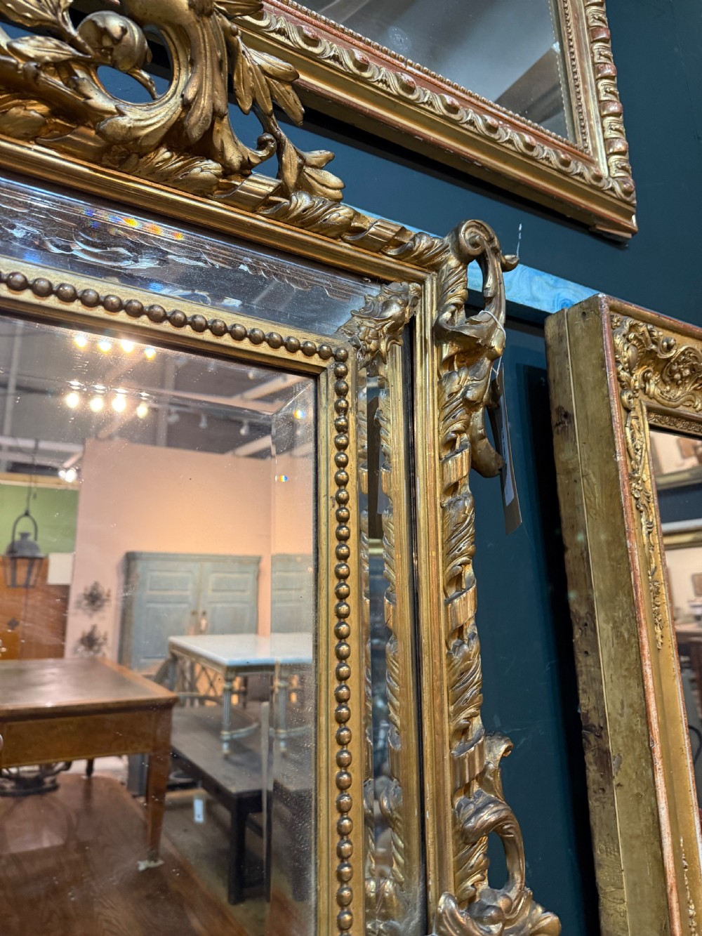 A 19th-century rectangular French giltwood wall mirror featuring elaborate cresting with cherubs, an urn finial, acanthus leaf scrolling, and a beaded inner border around a bevelled glass plate. View XIII