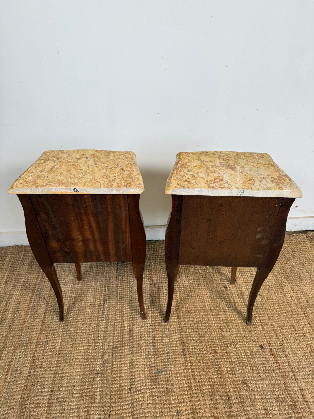 A pair of French Louis XV style bedside cabinets featuring variegated yellow marble tops, three marquetry inlaid drawers, brass mounts, and slender cabriole legs. View X