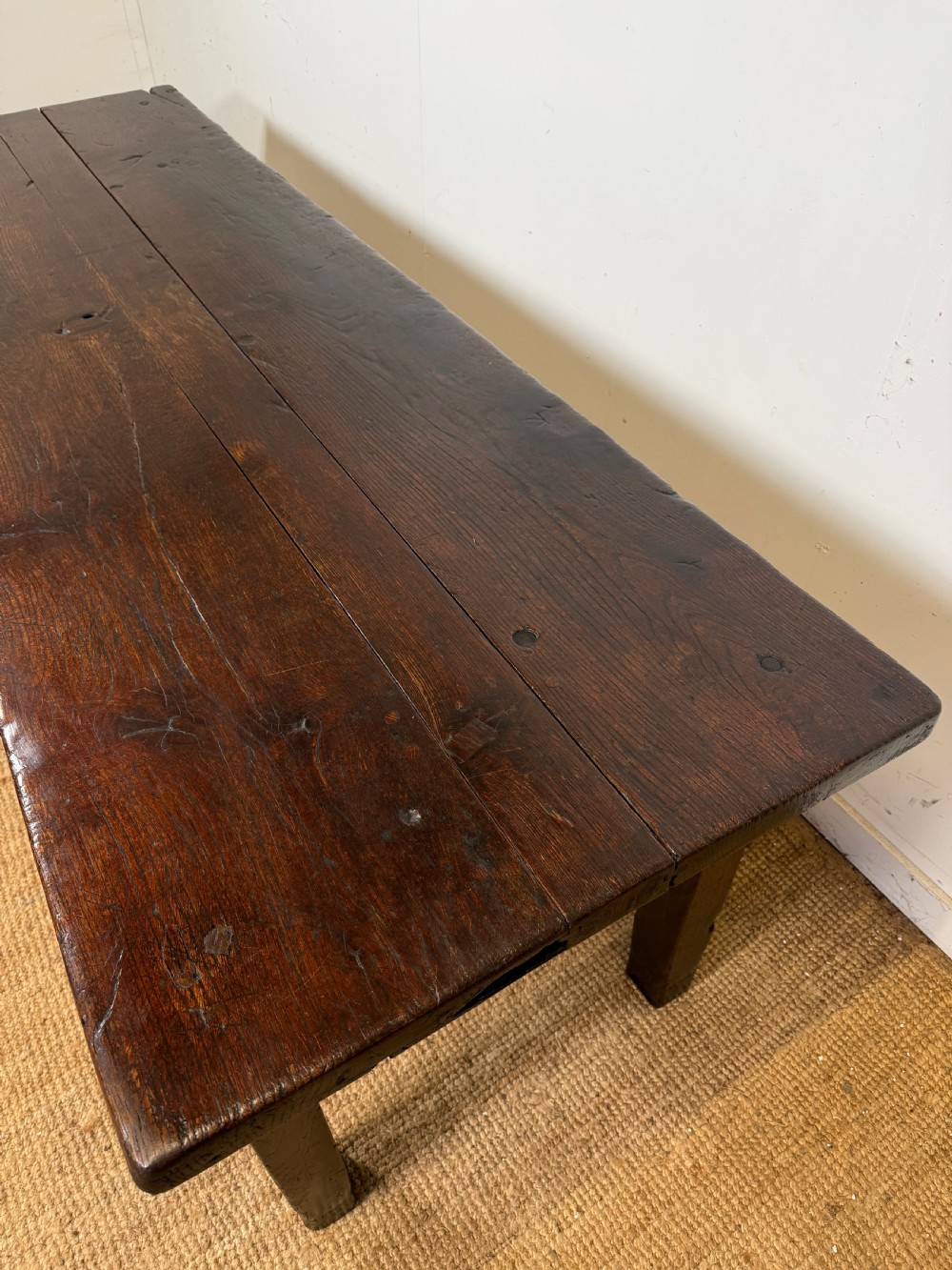 A long 18th century dark oak farmhouse dining table with a thick plank top and square legs. View III