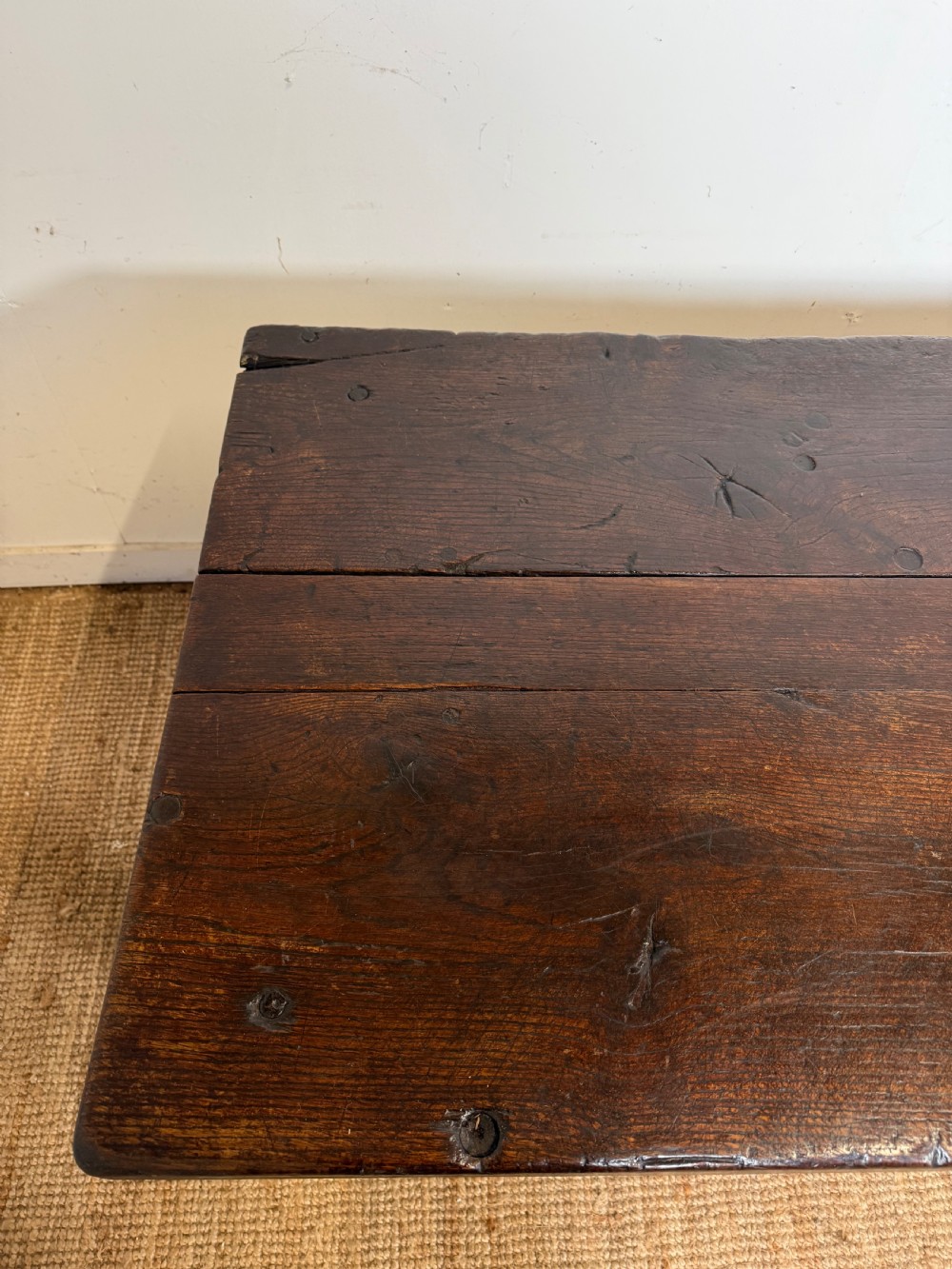 A long 18th century dark oak farmhouse dining table with a thick plank top and square legs. View VI