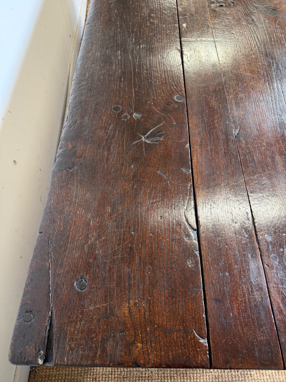 A long 18th century dark oak farmhouse dining table with a thick plank top and square legs. View VII