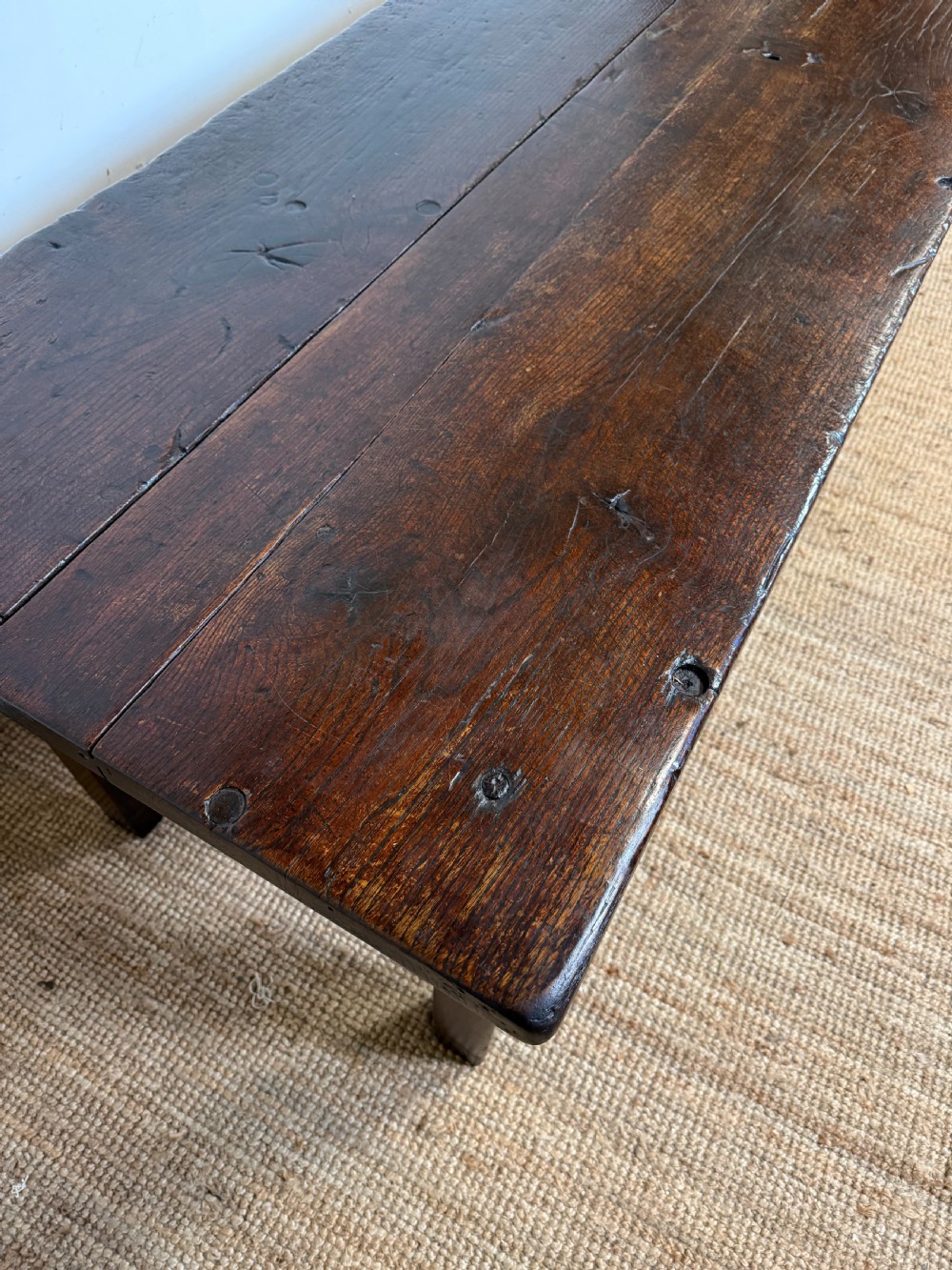 A long 18th century dark oak farmhouse dining table with a thick plank top and square legs. View VIII