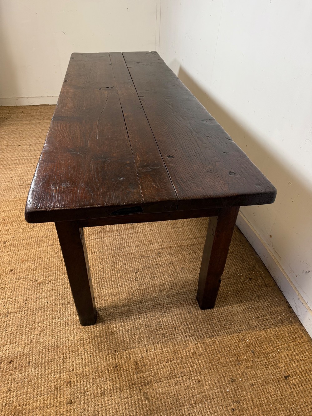 A long 18th century dark oak farmhouse dining table with a thick plank top and square legs. View XI