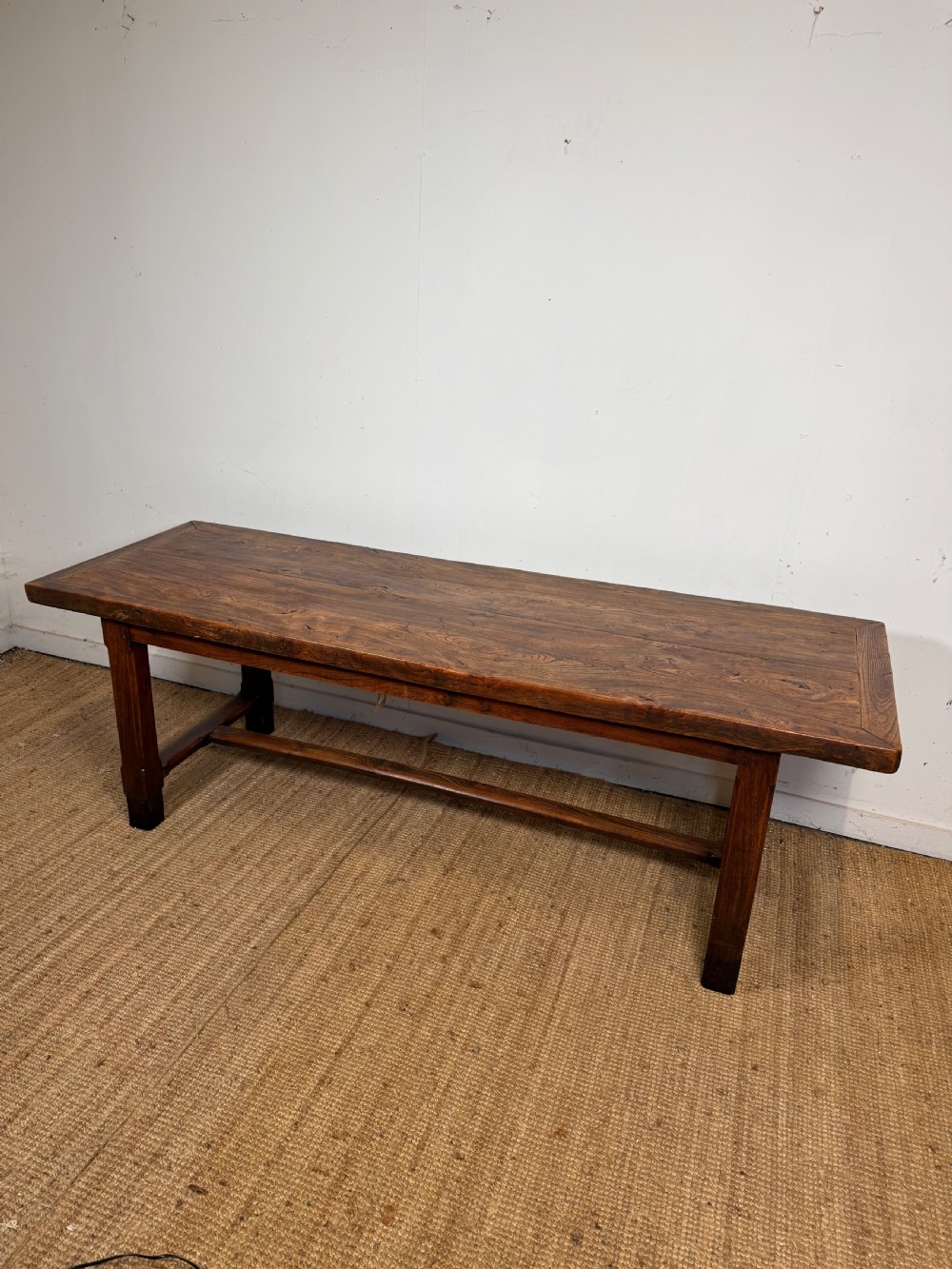 A long 19th-century rustic elm farmhouse dining table featuring a solid plank top and lower support stretchers. View II