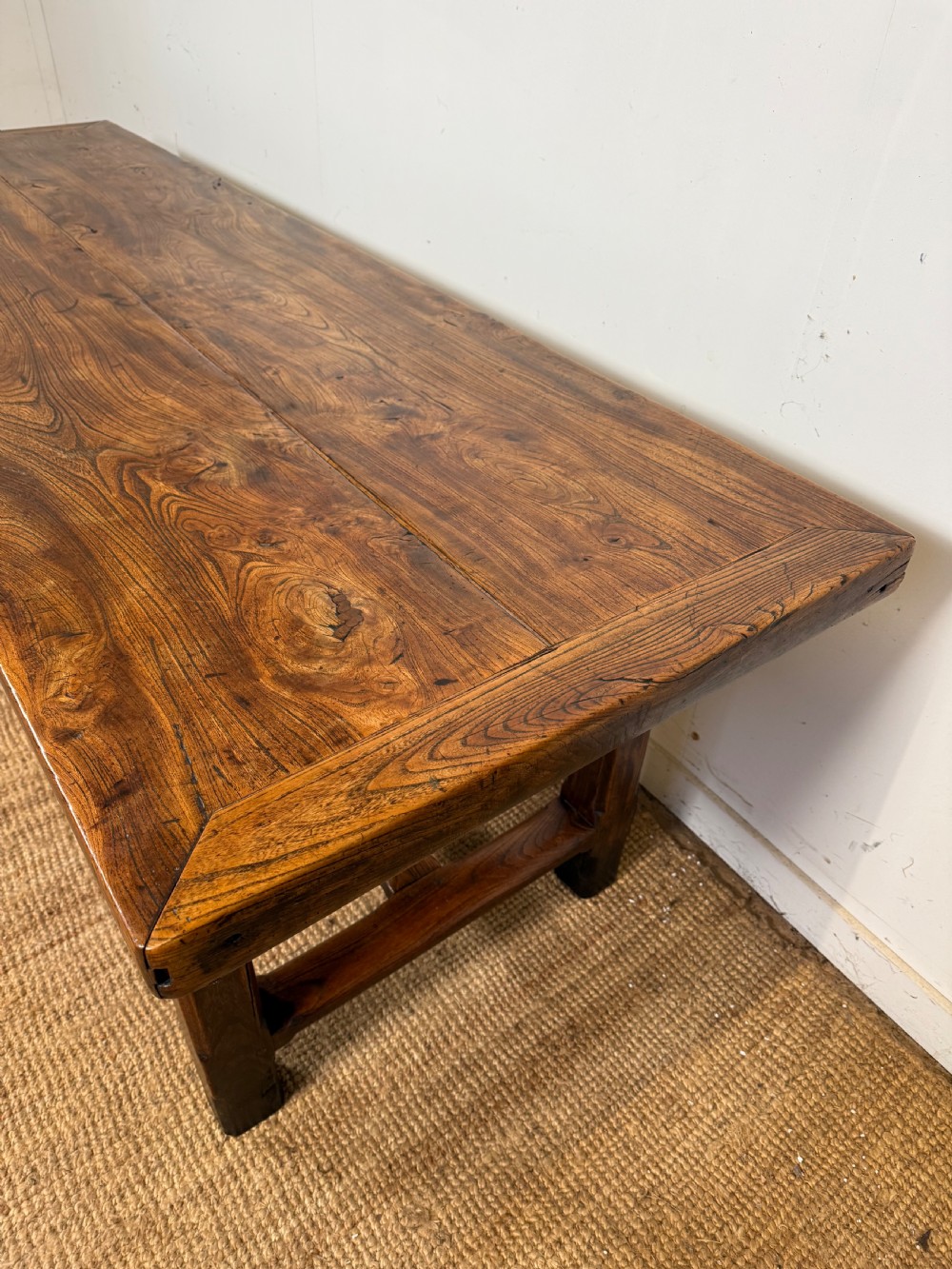 A long 19th-century rustic elm farmhouse dining table featuring a solid plank top and lower support stretchers. View III
