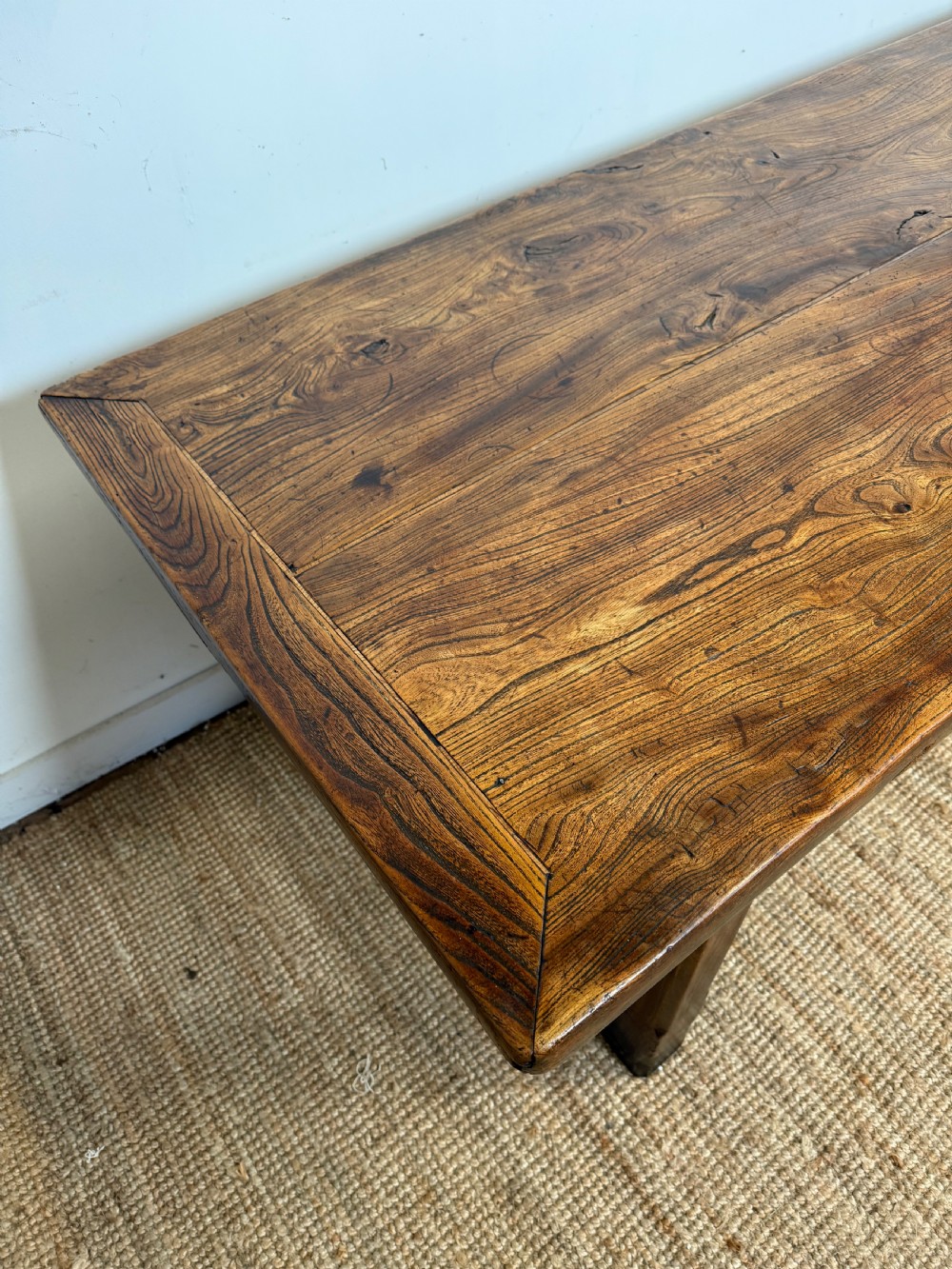 A long 19th-century rustic elm farmhouse dining table featuring a solid plank top and lower support stretchers. View IX