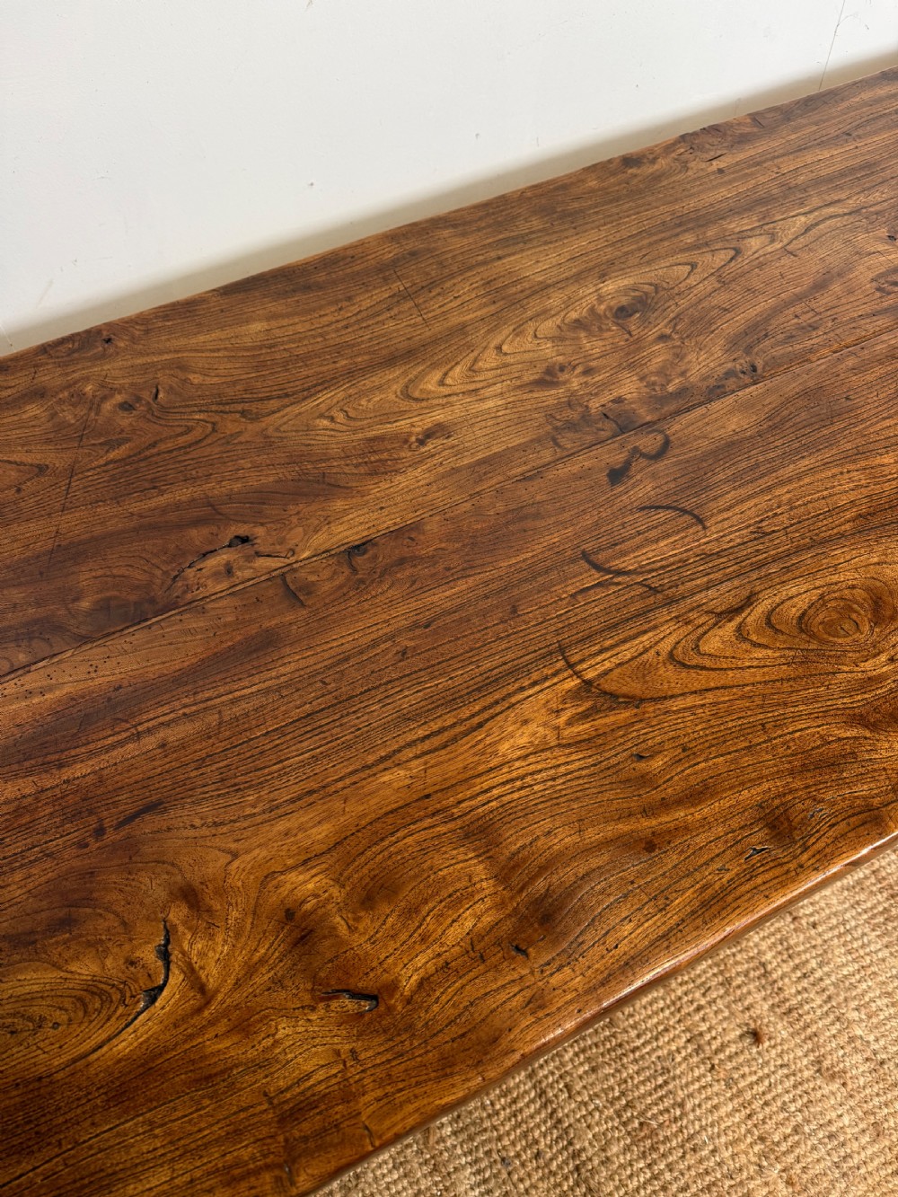 A long 19th-century rustic elm farmhouse dining table featuring a solid plank top and lower support stretchers. View XI