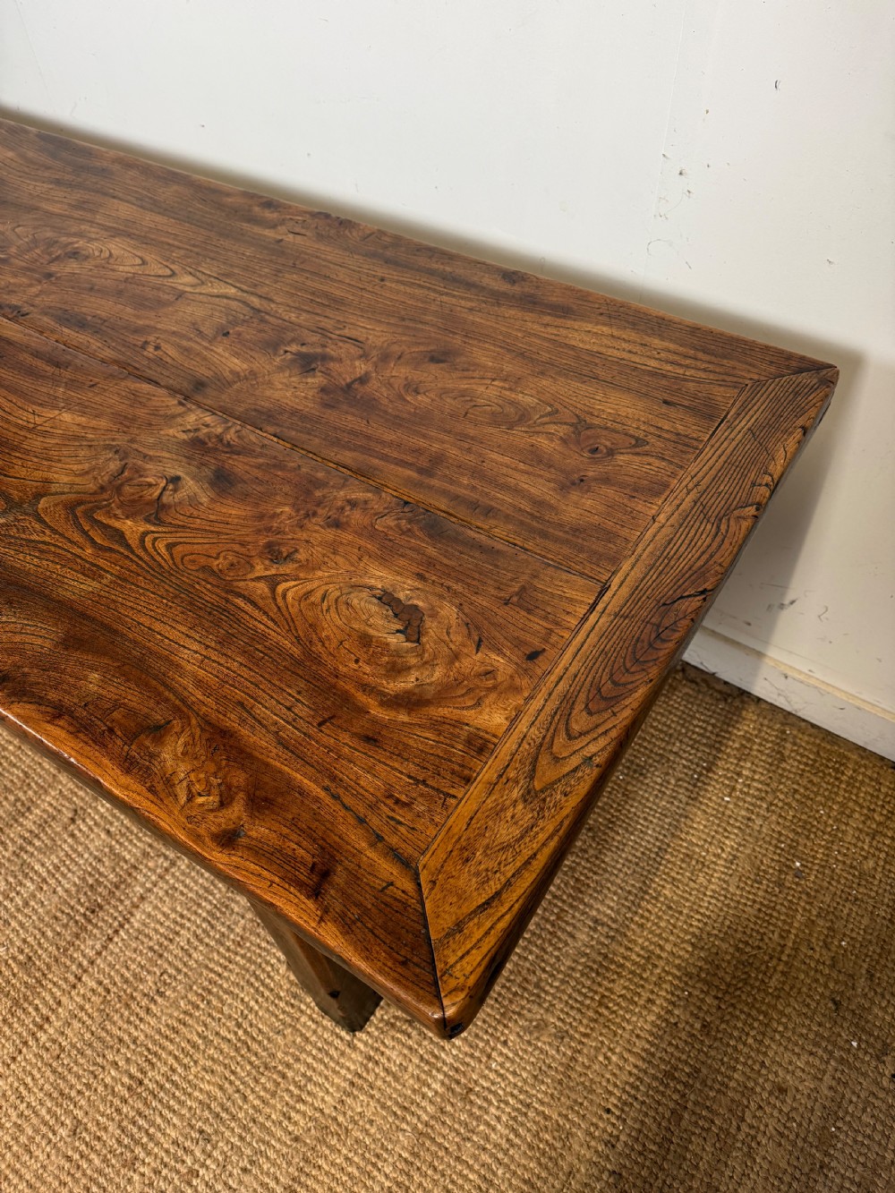 A long 19th-century rustic elm farmhouse dining table featuring a solid plank top and lower support stretchers. View XII