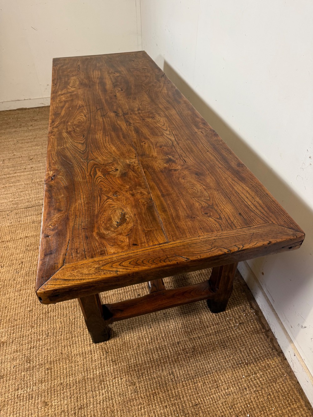 A long 19th-century rustic elm farmhouse dining table featuring a solid plank top and lower support stretchers. View XIII