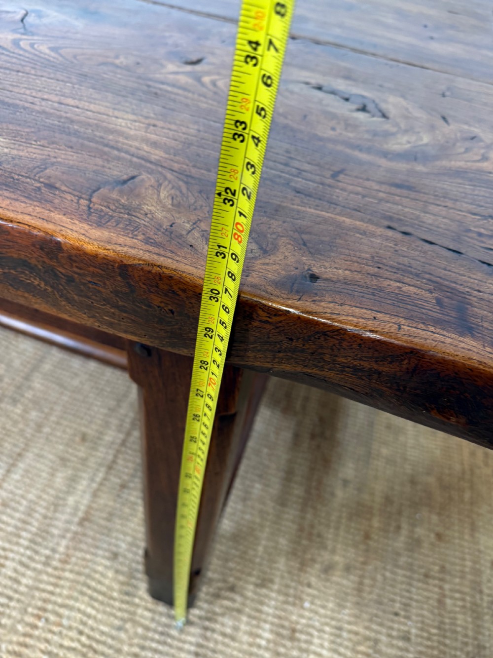 A long 19th-century rustic elm farmhouse dining table featuring a solid plank top and lower support stretchers. View XVII