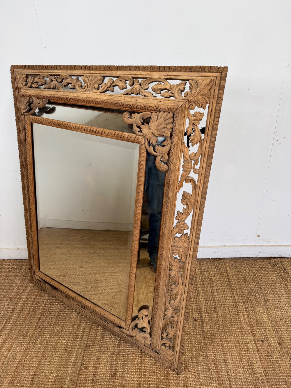 A large rectangular Henri II style scrubbed oak cushion mirror featuring intricate acanthus leaf relief carving on an openwork border.