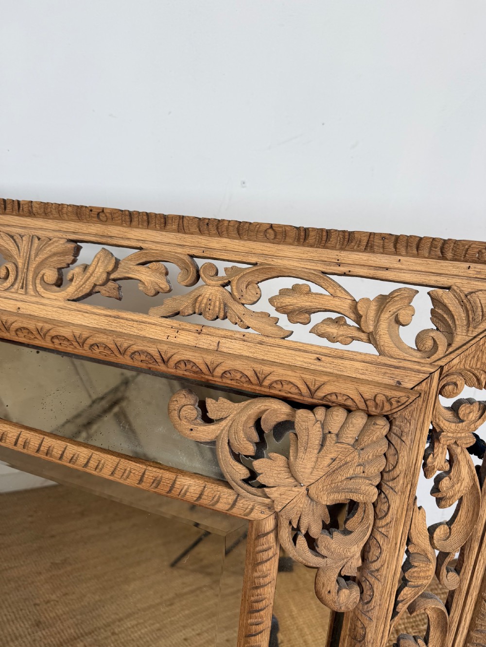 A large rectangular Henri II style scrubbed oak cushion mirror featuring intricate acanthus leaf relief carving on an openwork border. View III