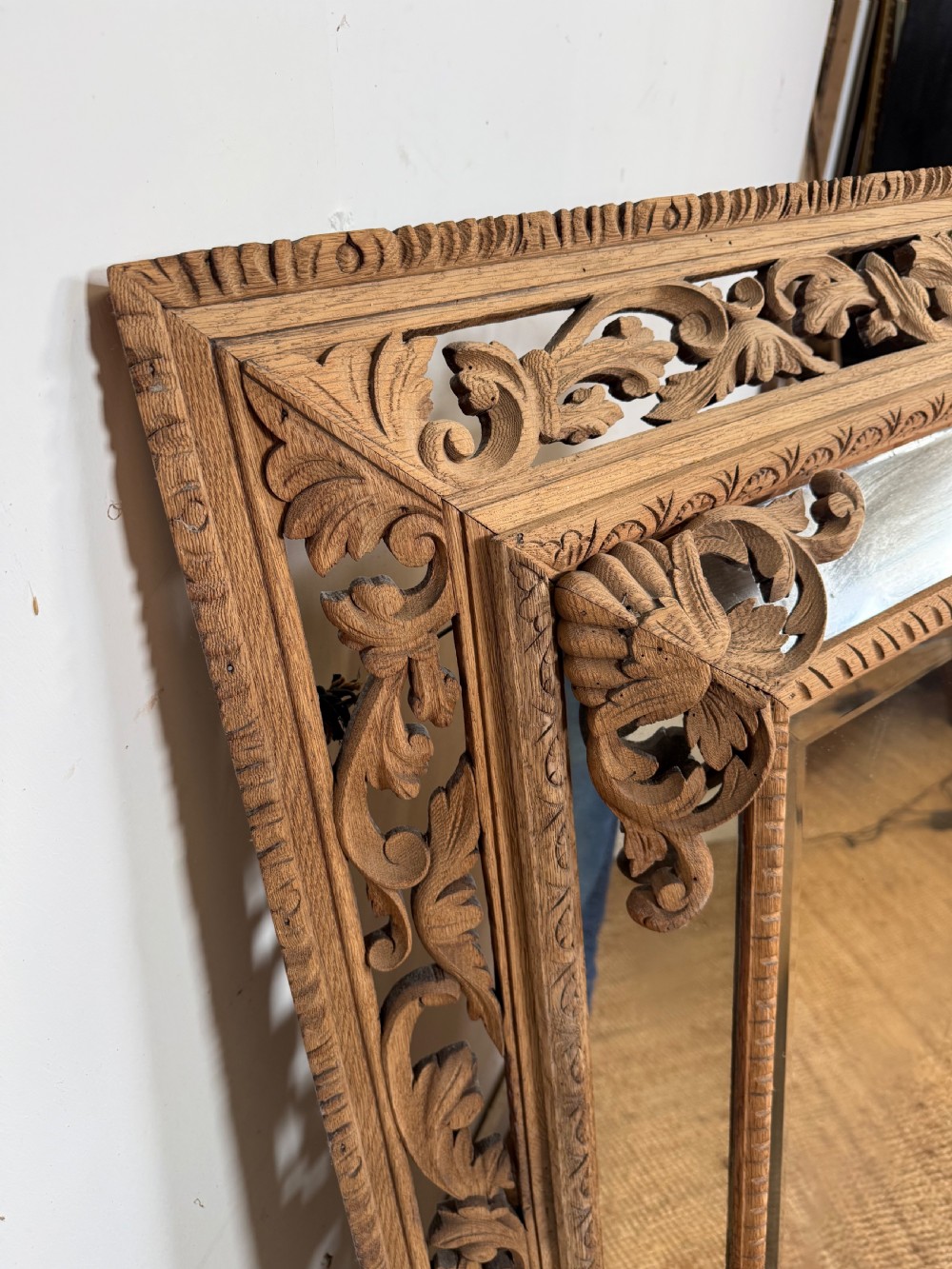 A large rectangular Henri II style scrubbed oak cushion mirror featuring intricate acanthus leaf relief carving on an openwork border. View V