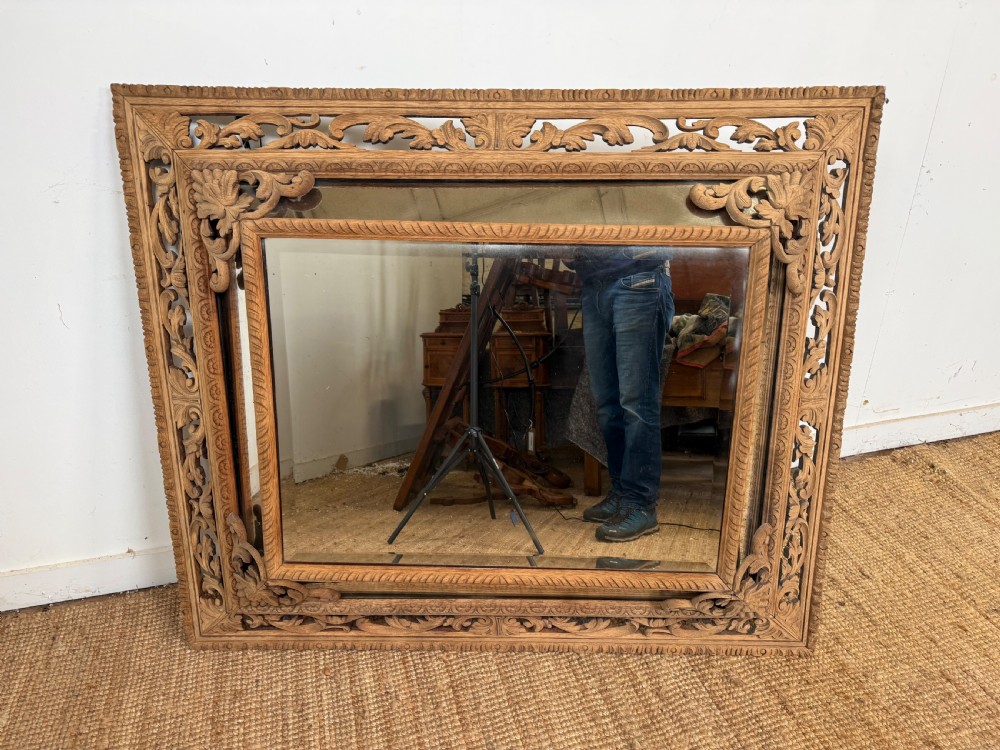 A large rectangular Henri II style scrubbed oak cushion mirror featuring intricate acanthus leaf relief carving on an openwork border. View IX