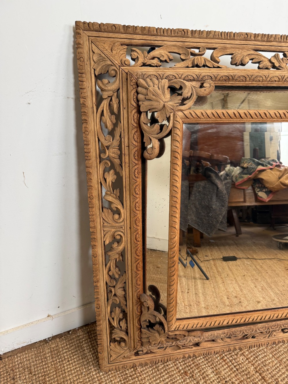A large rectangular Henri II style scrubbed oak cushion mirror featuring intricate acanthus leaf relief carving on an openwork border. View X