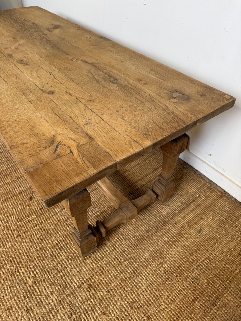 A long rectangular scrubbed oak refectory table featuring a solid top and trestle base with a low central stretcher. View II