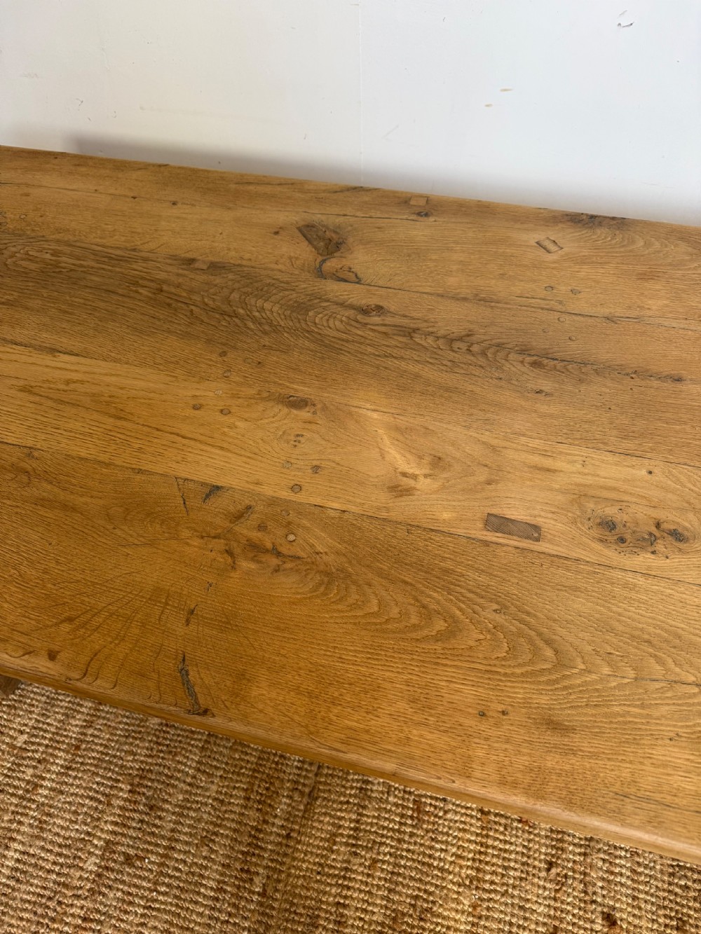 A long rectangular scrubbed oak refectory table featuring a solid top and trestle base with a low central stretcher. View VI