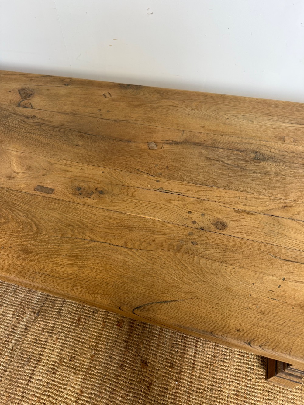 A long rectangular scrubbed oak refectory table featuring a solid top and trestle base with a low central stretcher. View VII