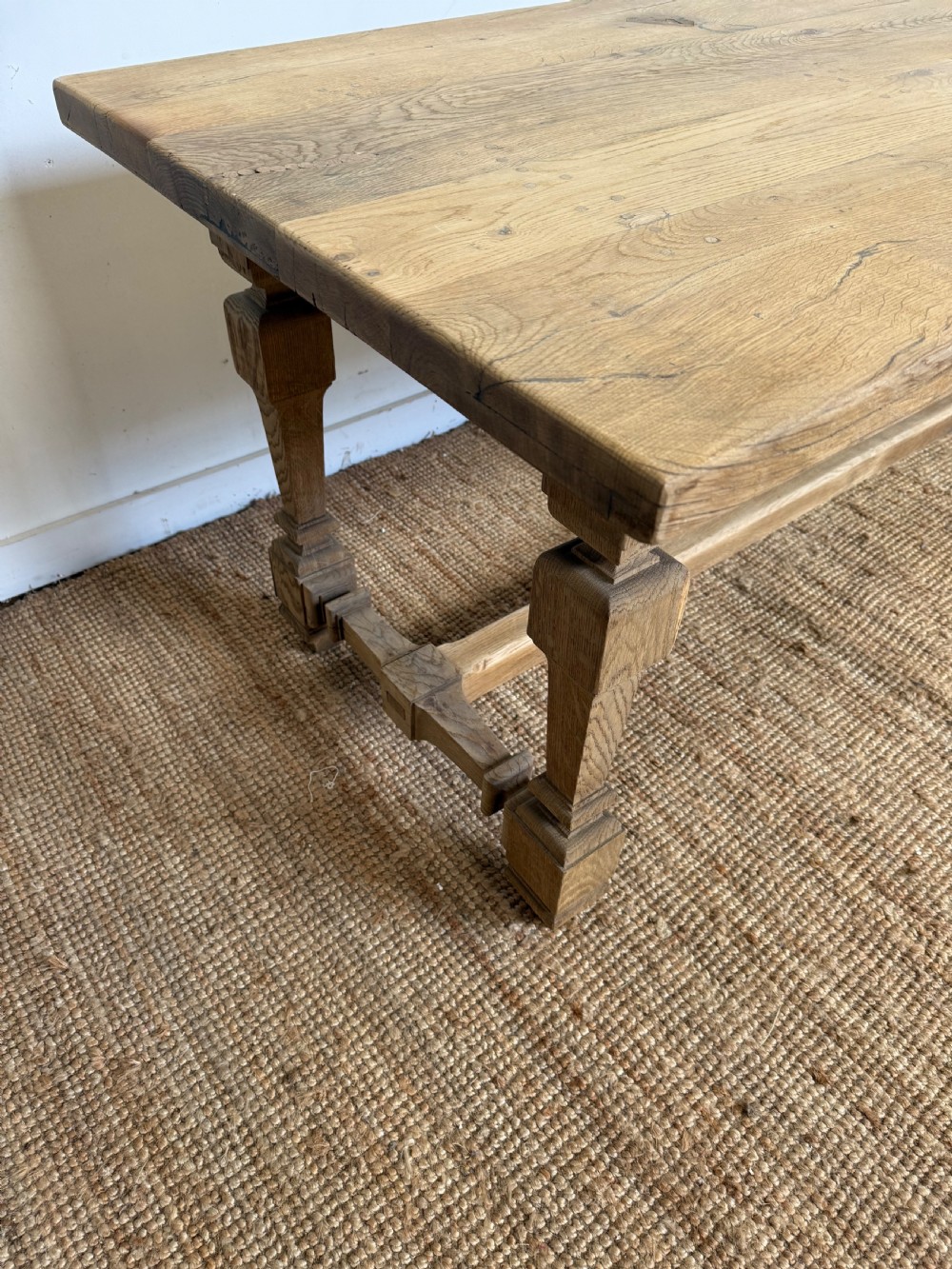 A long rectangular scrubbed oak refectory table featuring a solid top and trestle base with a low central stretcher. View IX