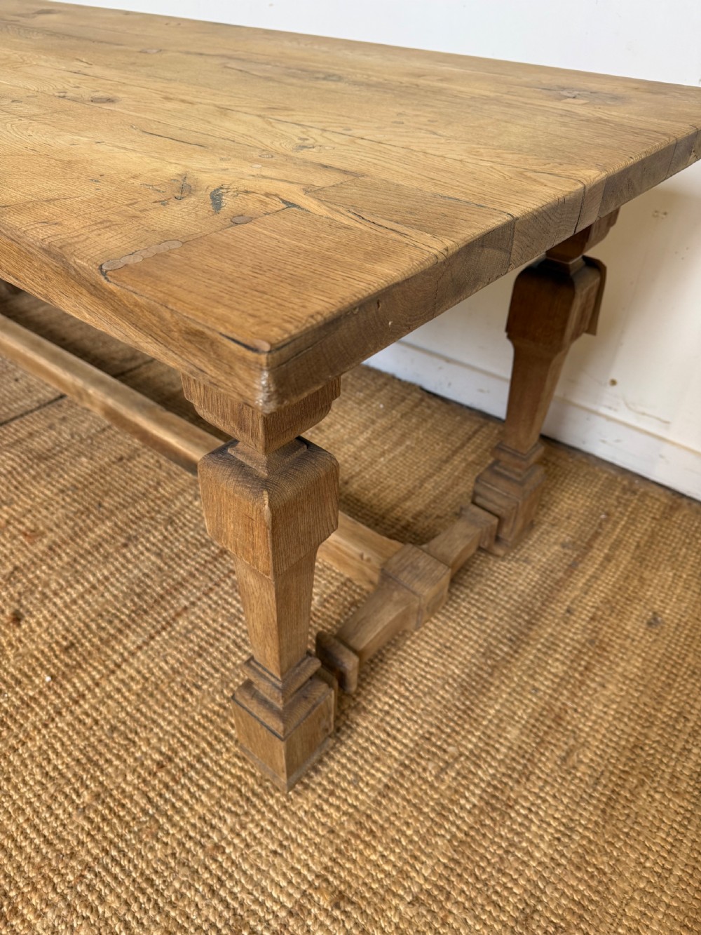 A long rectangular scrubbed oak refectory table featuring a solid top and trestle base with a low central stretcher. View XIII