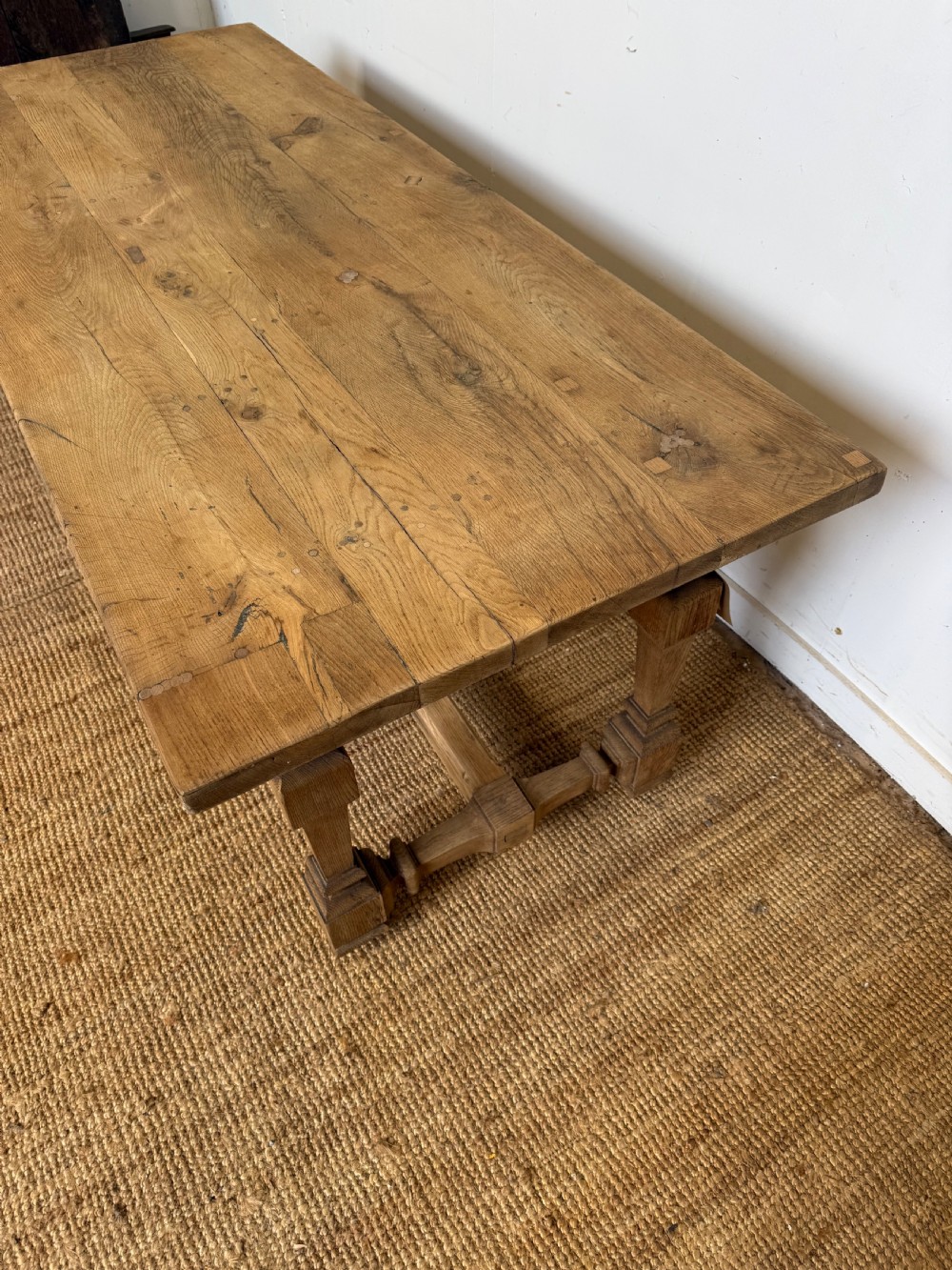 A long rectangular scrubbed oak refectory table featuring a solid top and trestle base with a low central stretcher. View XIV