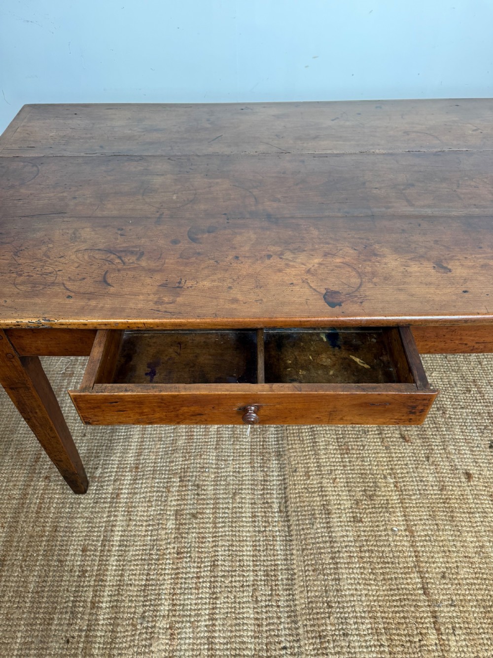 An antique French cherrywood farmhouse dining table featuring a plank top, single frieze drawer, and four square tapered legs. View IV
