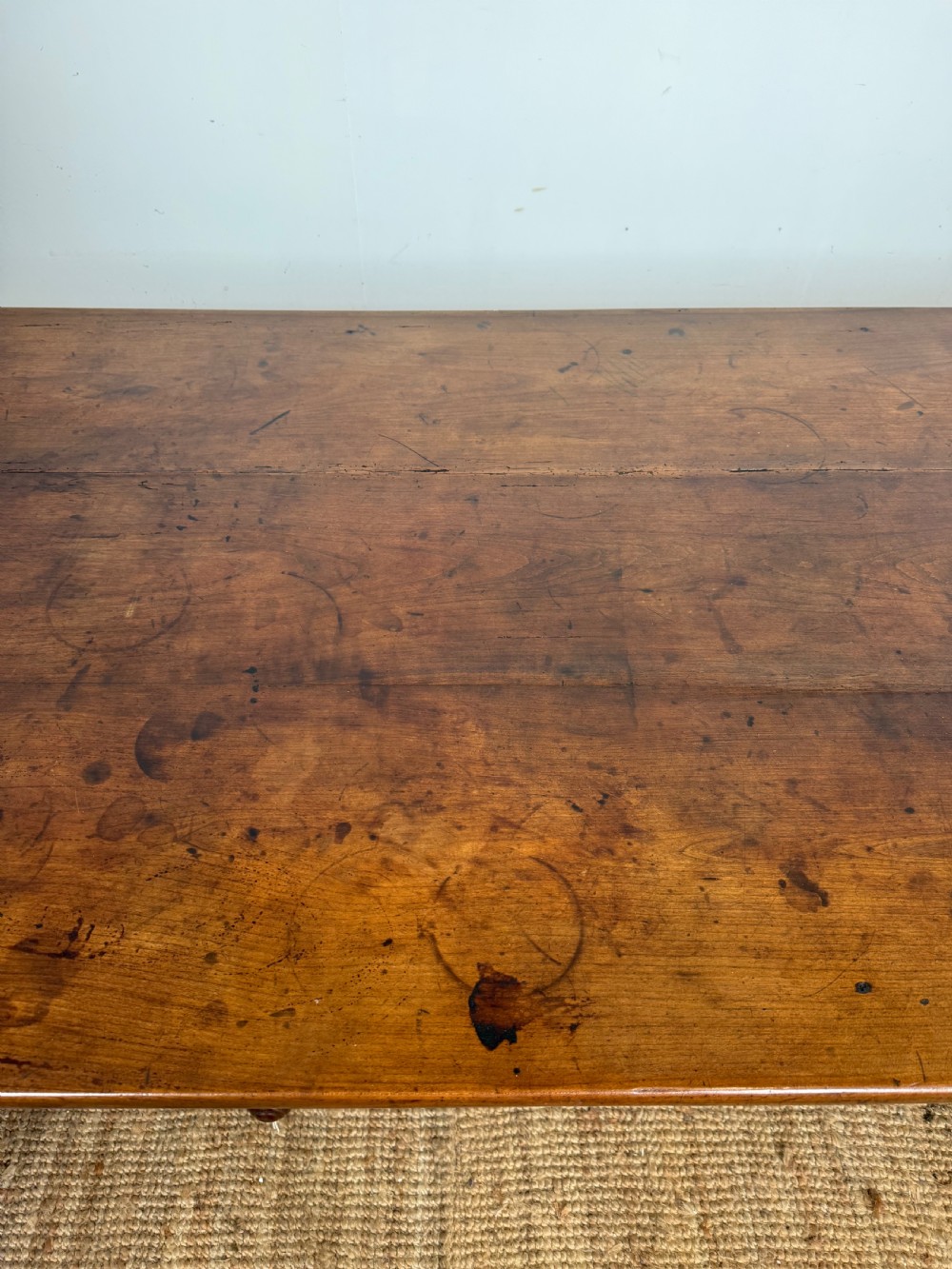 An antique French cherrywood farmhouse dining table featuring a plank top, single frieze drawer, and four square tapered legs. View VII
