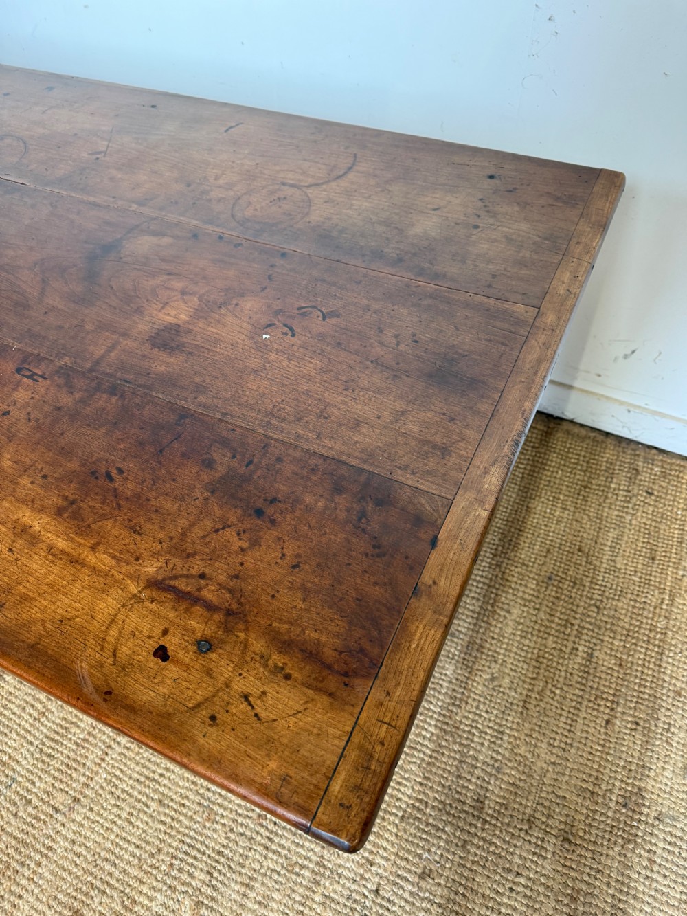 An antique French cherrywood farmhouse dining table featuring a plank top, single frieze drawer, and four square tapered legs. View IX