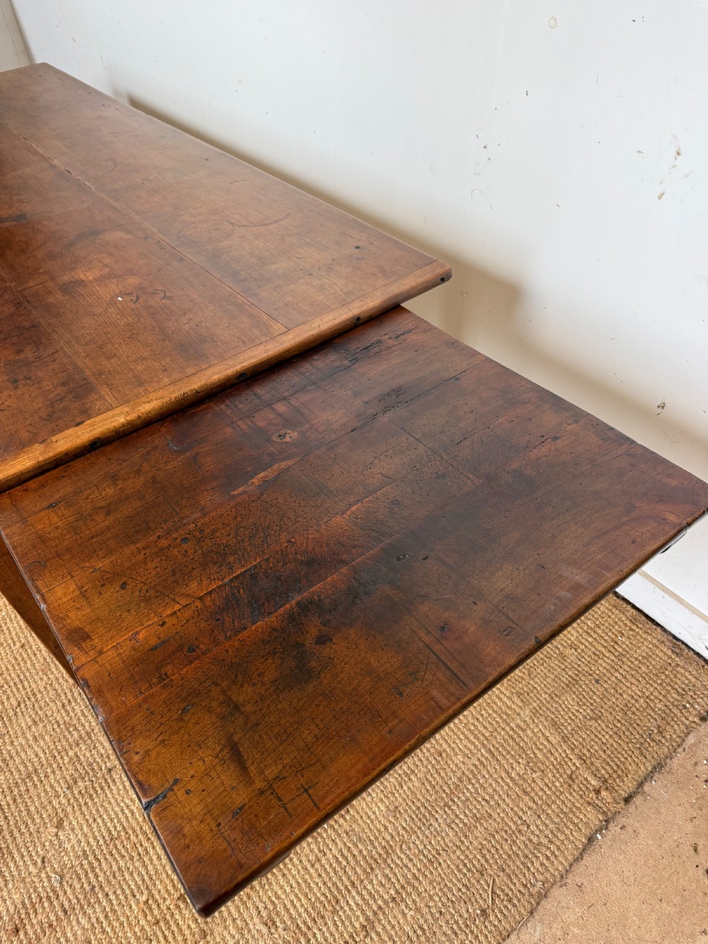 An antique French cherrywood farmhouse dining table featuring a plank top, single frieze drawer, and four square tapered legs. View XI