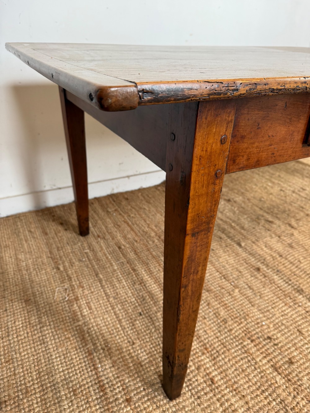 An antique French cherrywood farmhouse dining table featuring a plank top, single frieze drawer, and four square tapered legs. View XII