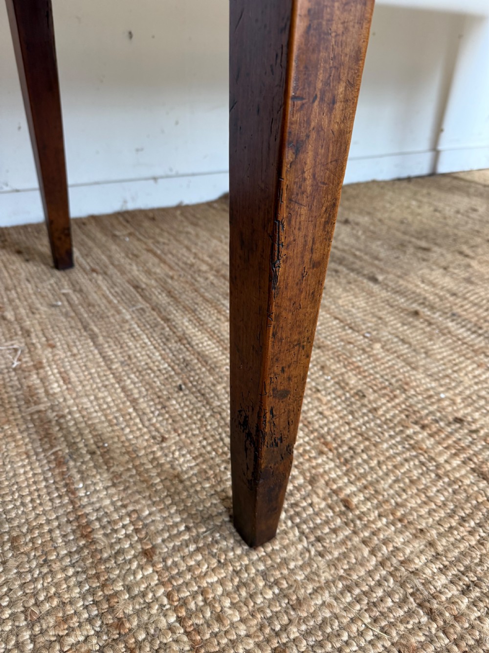 An antique French cherrywood farmhouse dining table featuring a plank top, single frieze drawer, and four square tapered legs. View XIII