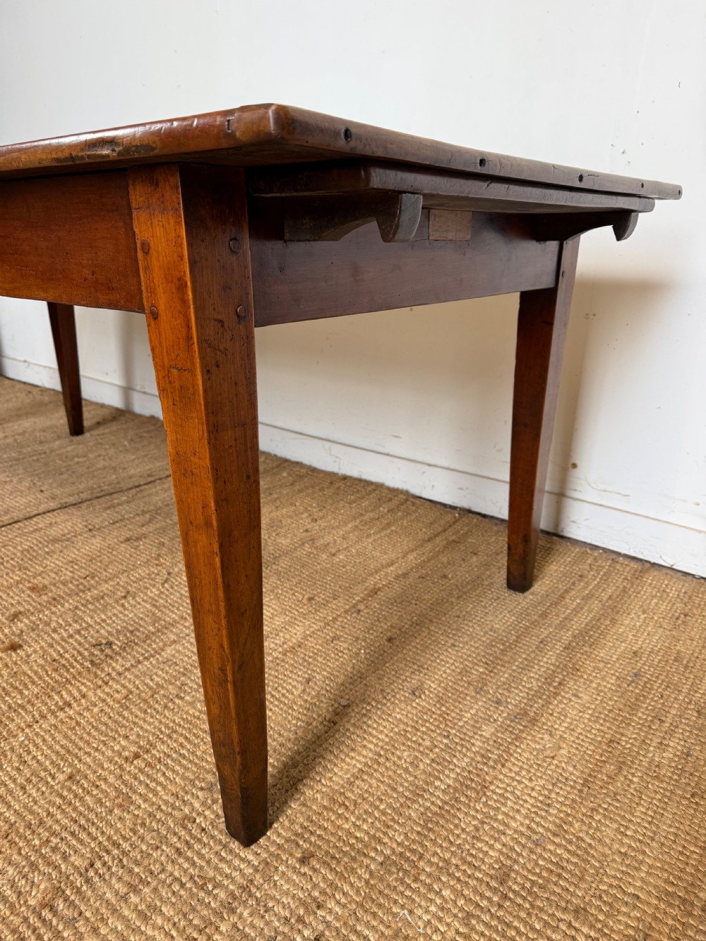 An antique French cherrywood farmhouse dining table featuring a plank top, single frieze drawer, and four square tapered legs. View XIV