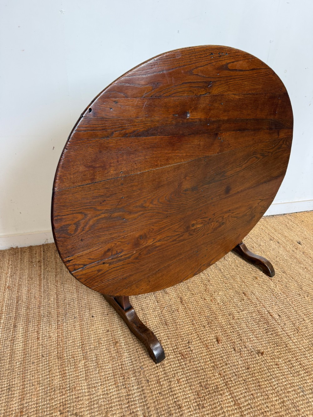 A 19th-century French dark oak Vendange table featuring a large oval tilting top set on a trestle base. View II