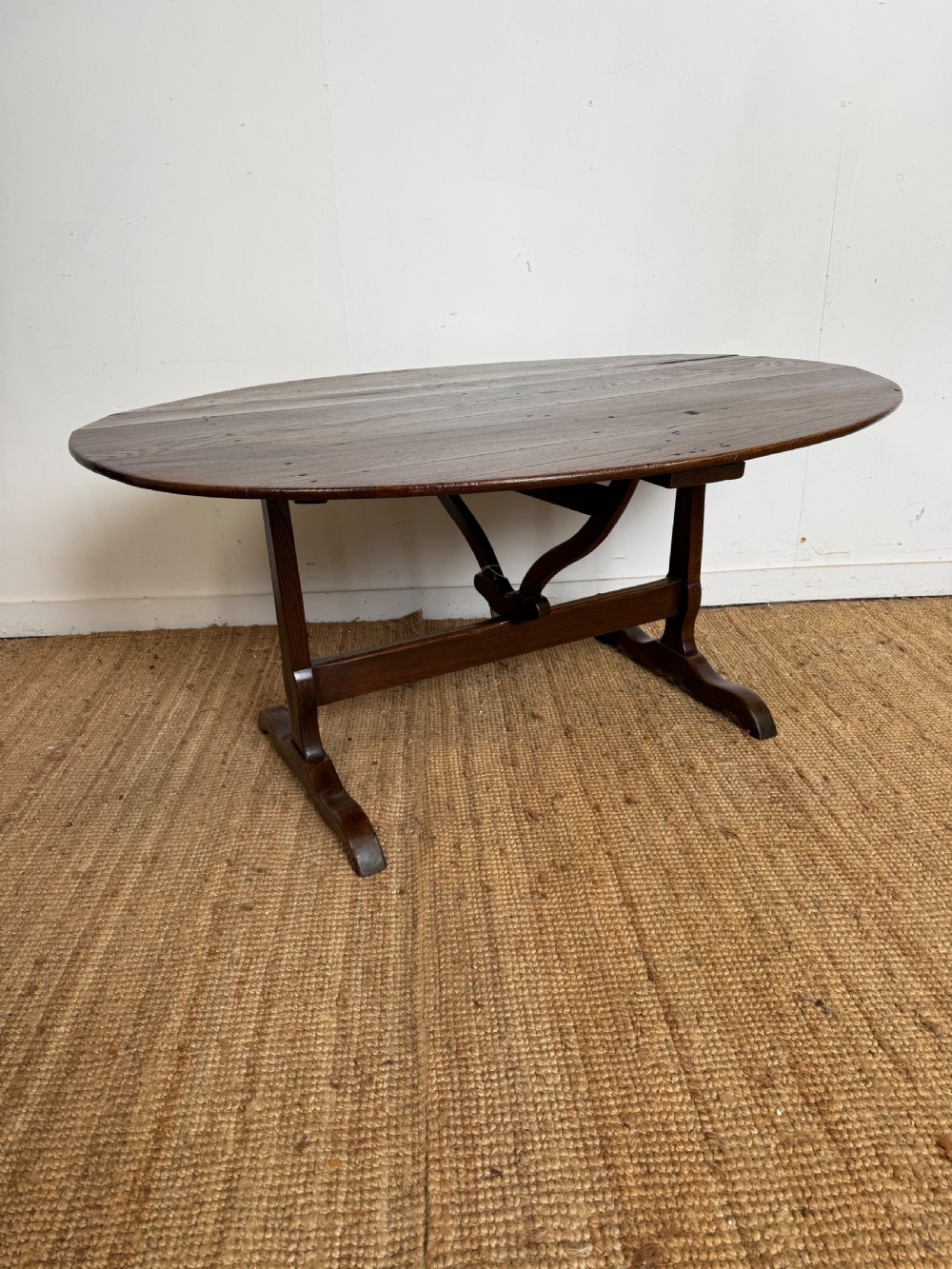 A 19th-century French dark oak Vendange table featuring a large oval tilting top set on a trestle base. View III