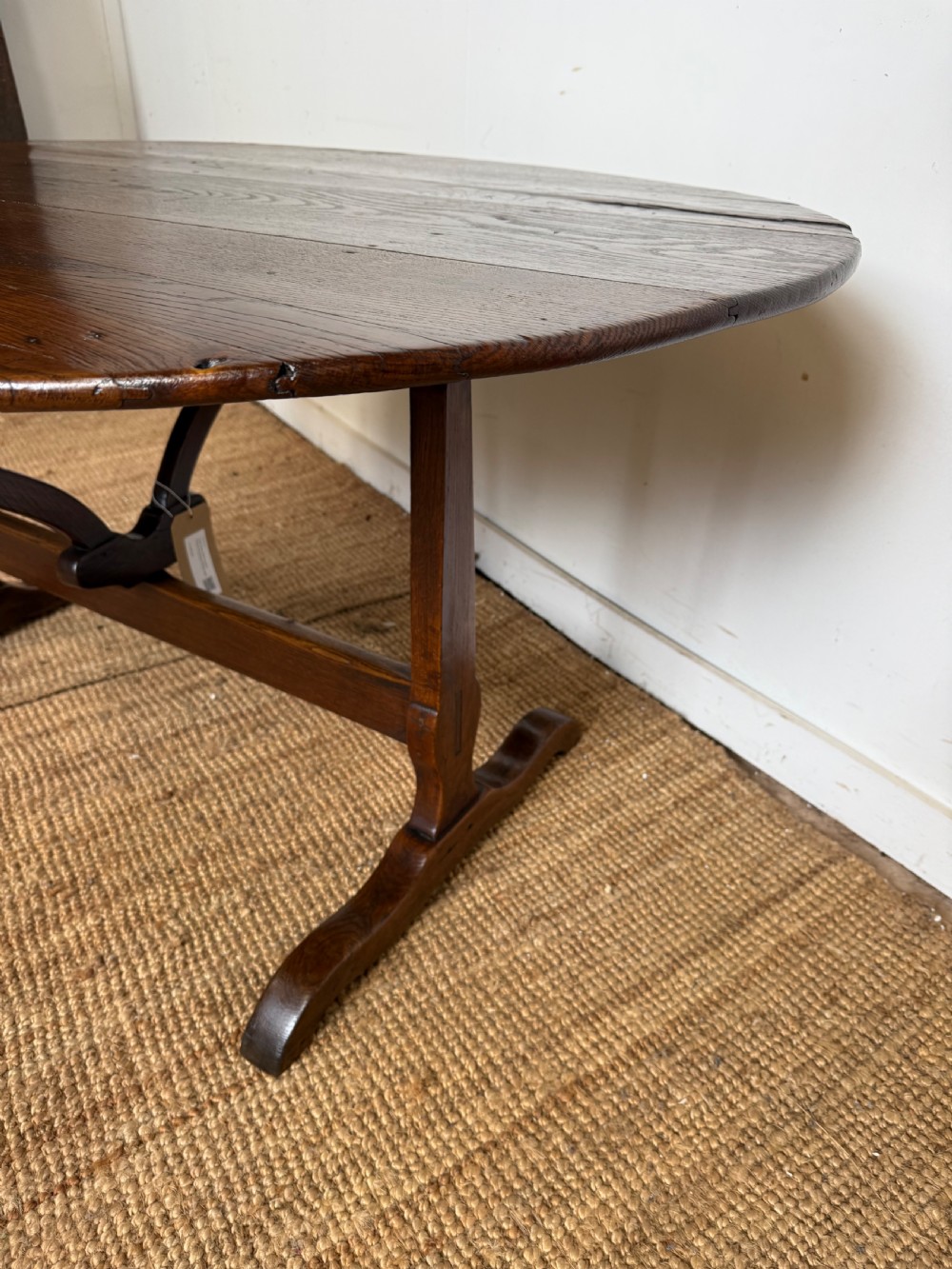 A 19th-century French dark oak Vendange table featuring a large oval tilting top set on a trestle base. View IV