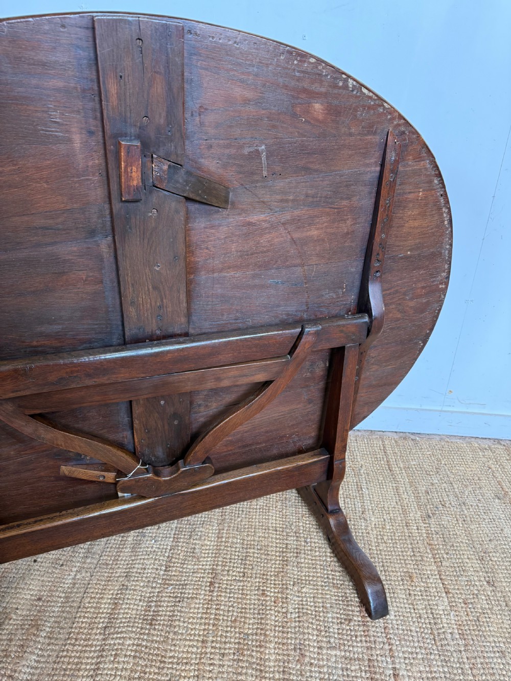 A 19th-century French dark oak Vendange table featuring a large oval tilting top set on a trestle base. View VII