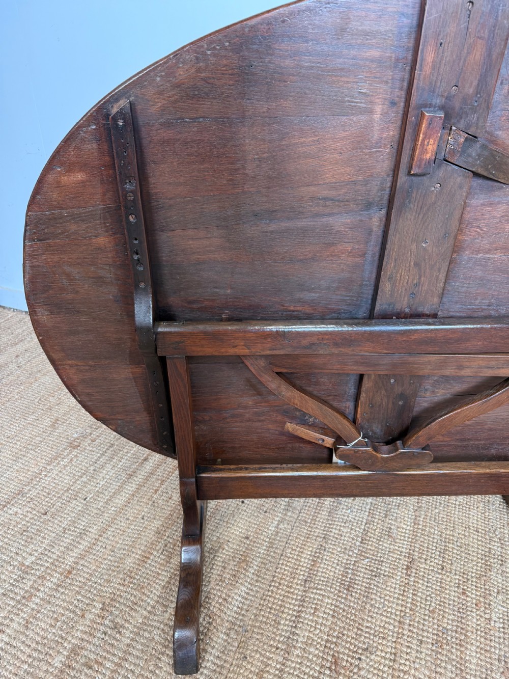 A 19th-century French dark oak Vendange table featuring a large oval tilting top set on a trestle base. View VIII