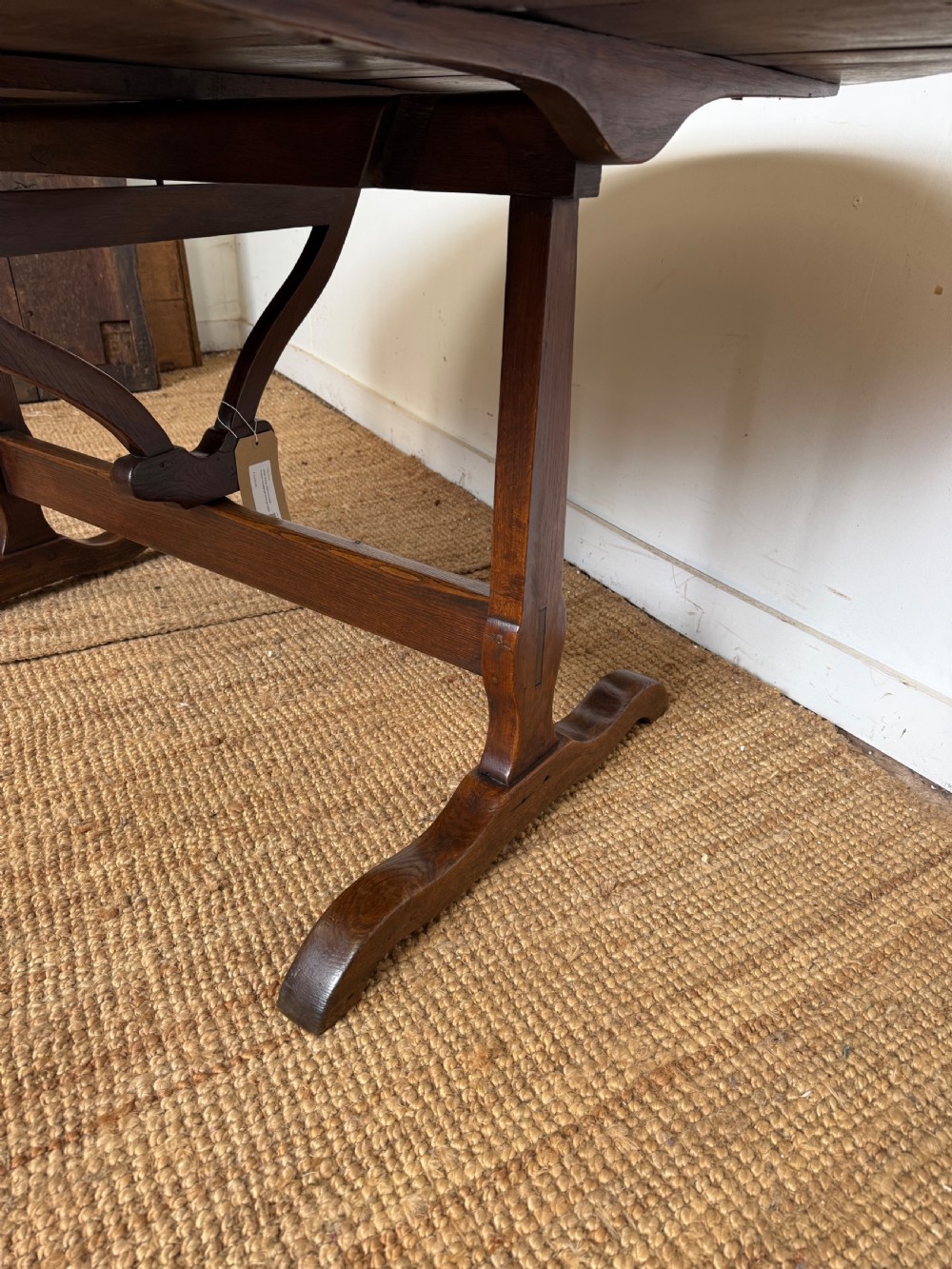 A 19th-century French dark oak Vendange table featuring a large oval tilting top set on a trestle base. View IX
