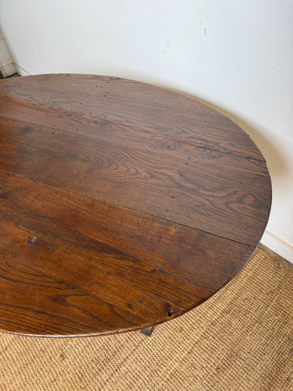 A 19th-century French dark oak Vendange table featuring a large oval tilting top set on a trestle base. View X