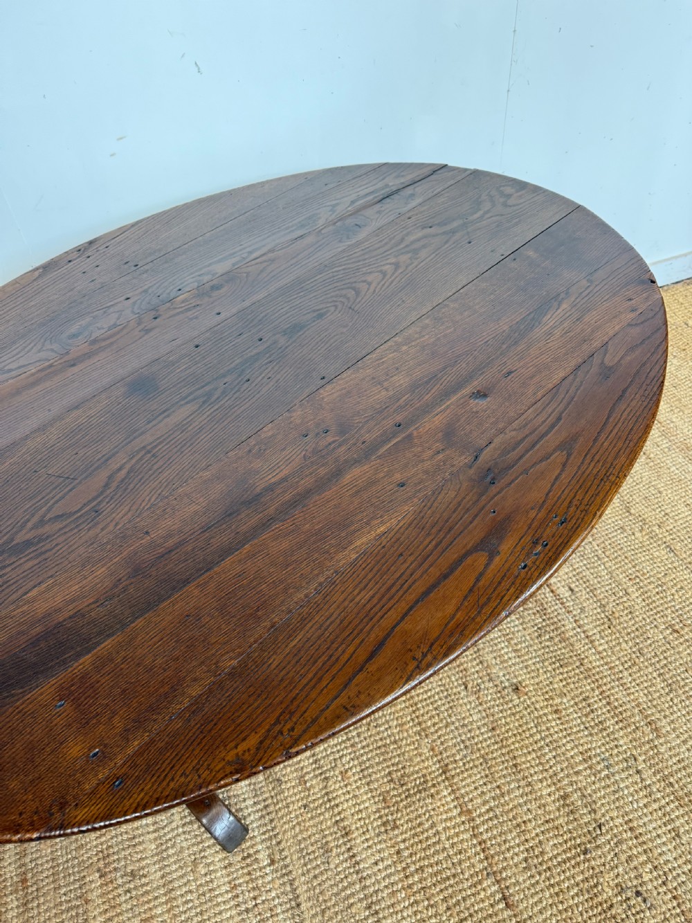 A 19th-century French dark oak Vendange table featuring a large oval tilting top set on a trestle base. View XI