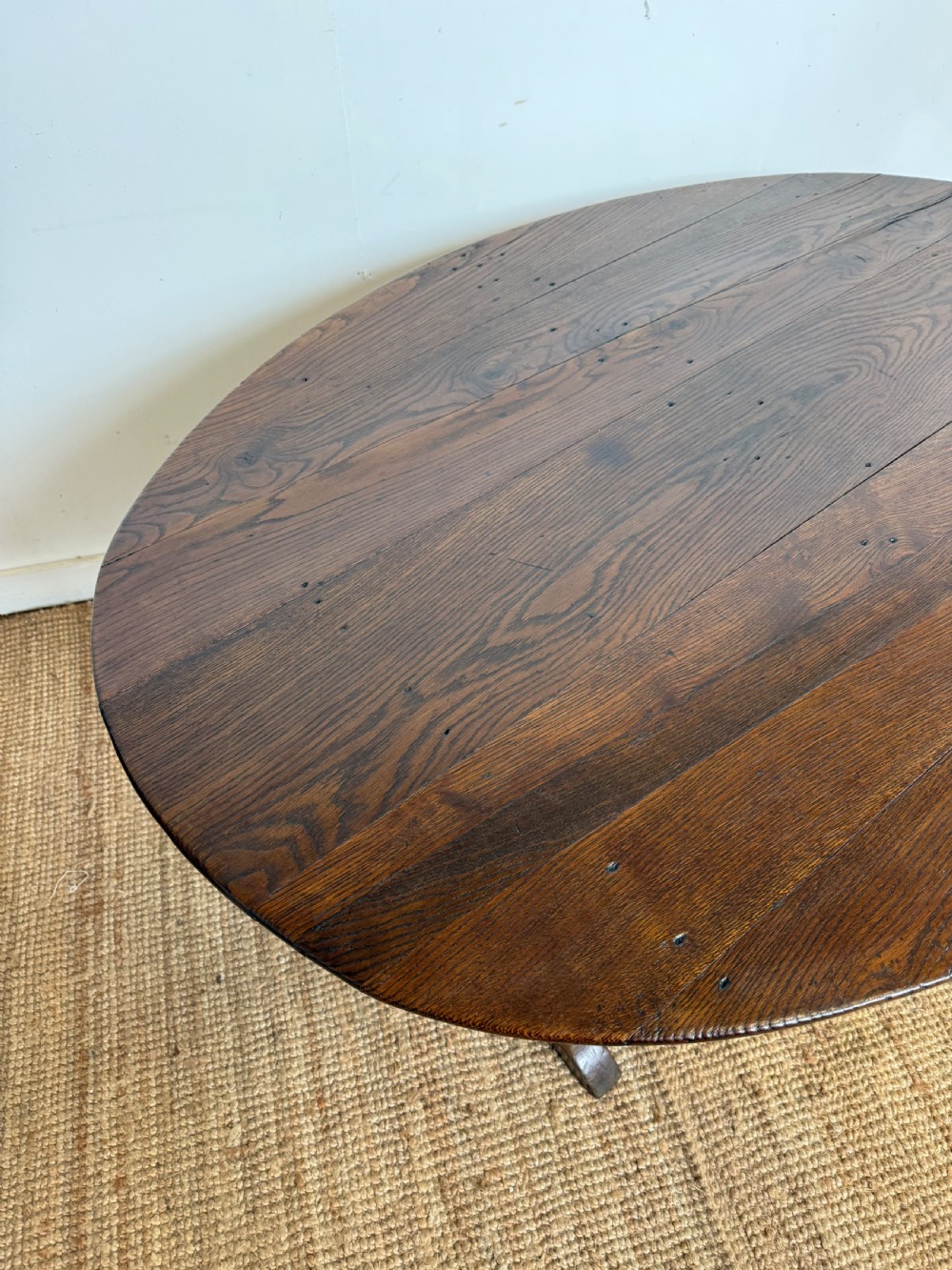 A 19th-century French dark oak Vendange table featuring a large oval tilting top set on a trestle base. View XII