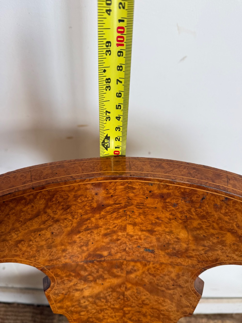 Late 19th-century burr elm desk chair featuring a curved backrest, central splat, dark leather studded upholstery, and tapered legs with brass feet. View VII