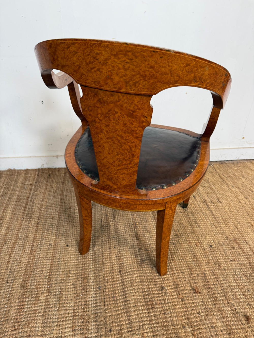 Late 19th-century burr elm desk chair featuring a curved backrest, central splat, dark leather studded upholstery, and tapered legs with brass feet. View VIII