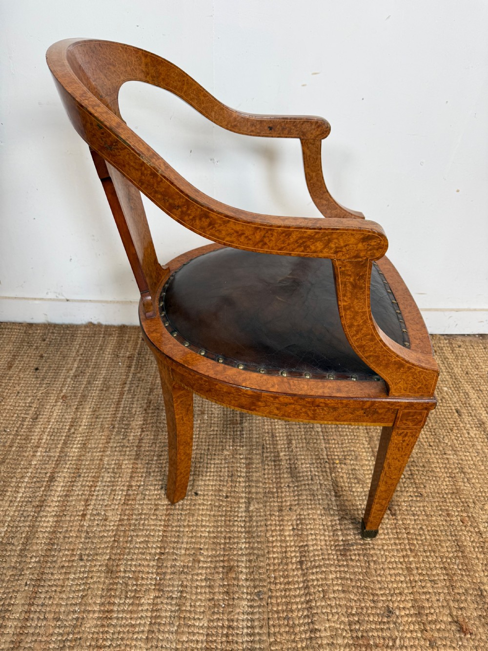 Late 19th-century burr elm desk chair featuring a curved backrest, central splat, dark leather studded upholstery, and tapered legs with brass feet. View IX