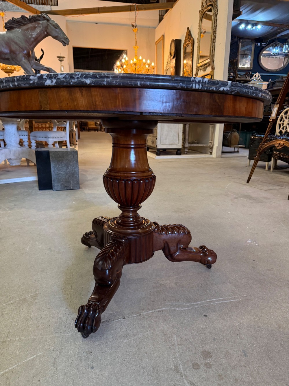 A 19th-century circular centre table featuring a dark veined marble top supported by a carved mahogany pedestal stem and a tripartite claw-foot base. View IV