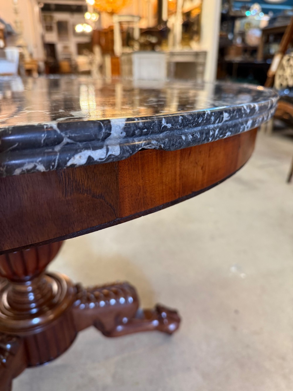 A 19th-century circular centre table featuring a dark veined marble top supported by a carved mahogany pedestal stem and a tripartite claw-foot base. View VIII